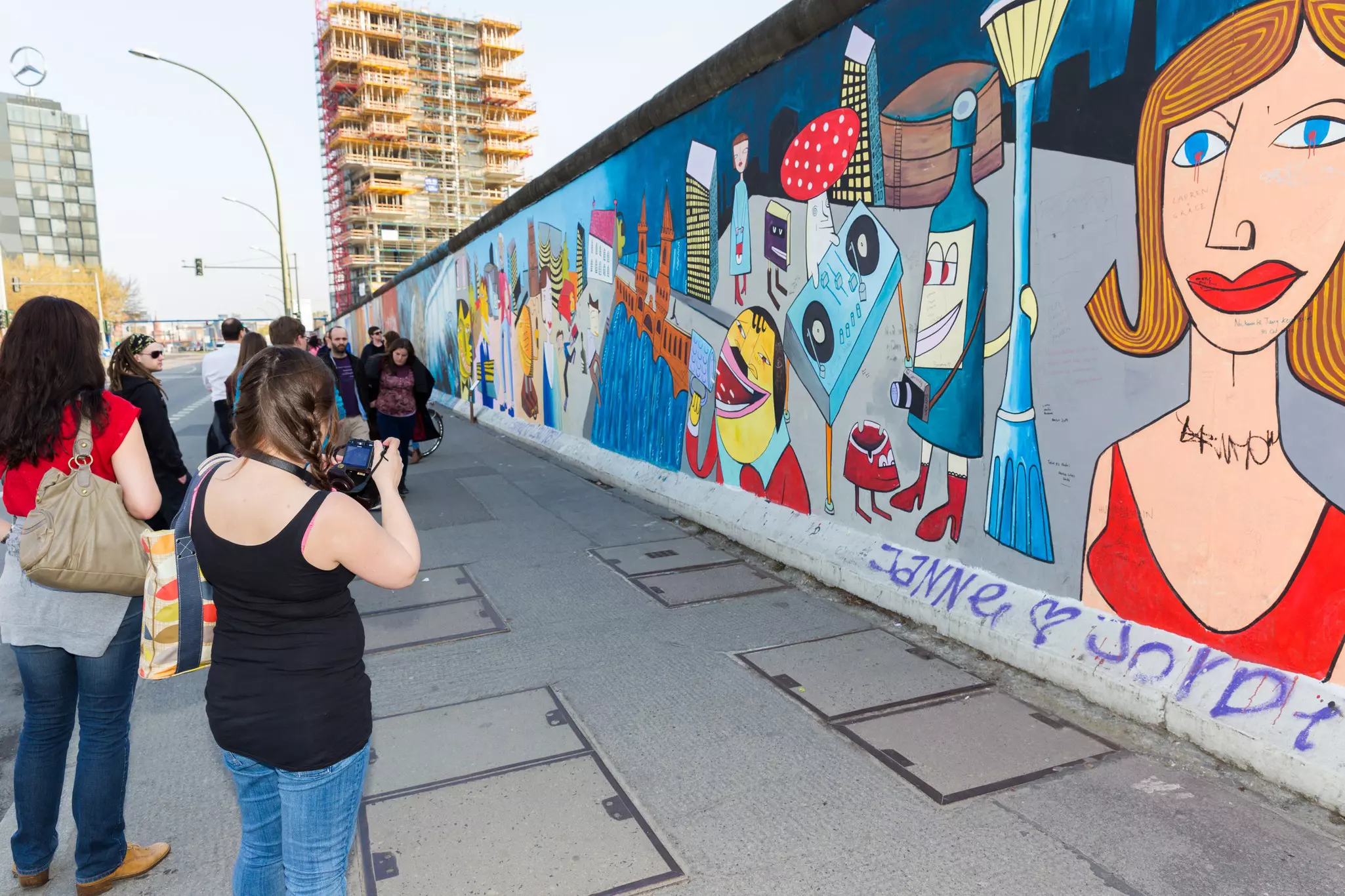 Girl looks over a barrier at a penguin staring back up at her © Sarah Stocking / Lonely Planet