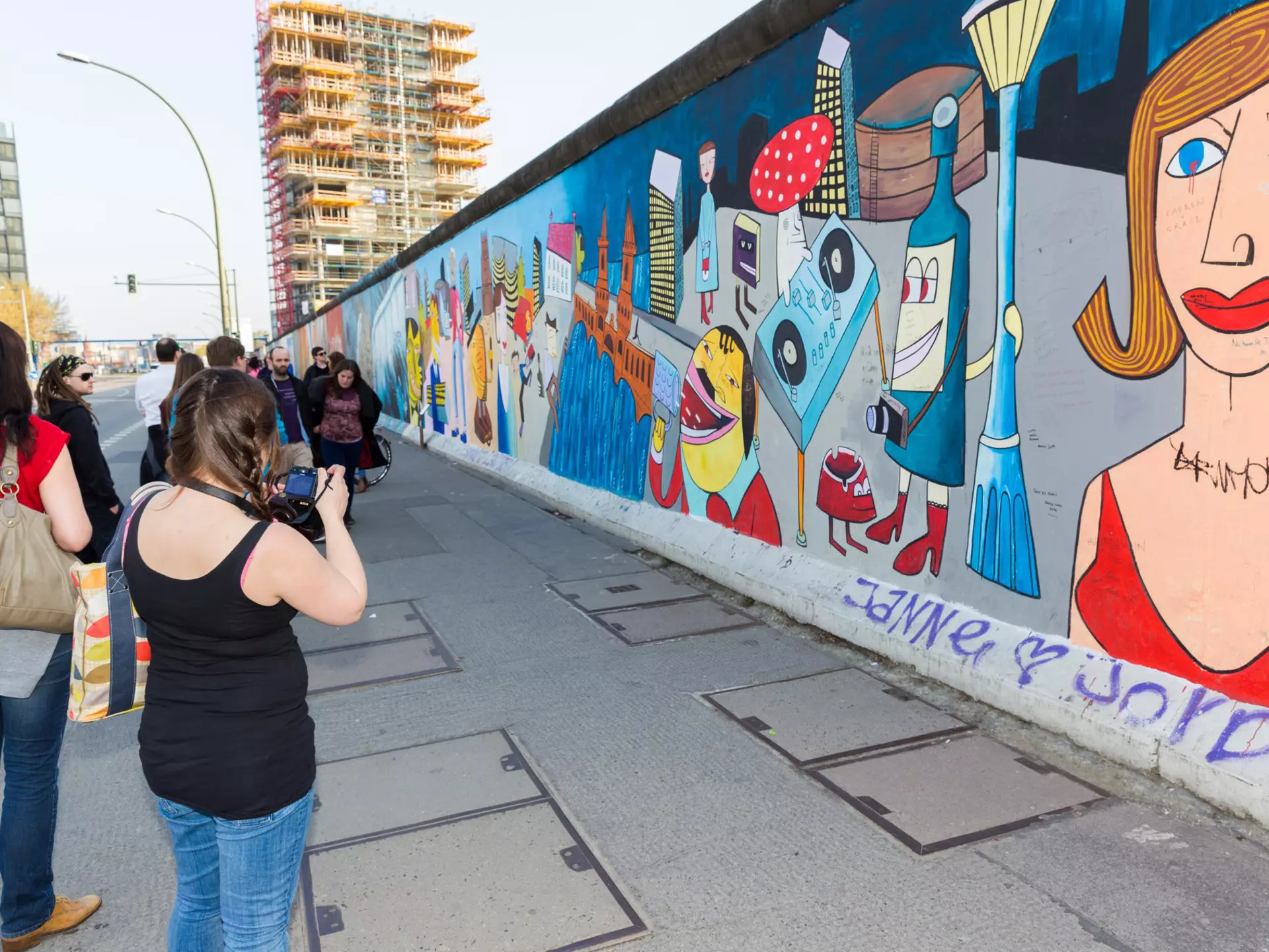 Girl looks over a barrier at a penguin staring back up at her © Sarah Stocking / Lonely Planet