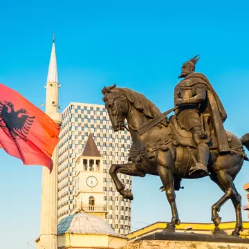Skanderbeg square with flag and monument, and The Et'hem Bey Mosque, in the center of Tirana city, Albania.