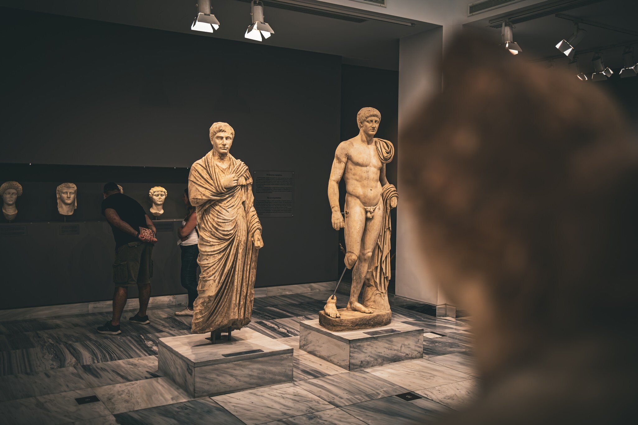 A couple admire the amazing ancient sculptures from the Roman era in Crete, in the Archaeological Museum of Heraklion, Crete.