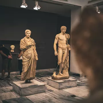 A couple admire the amazing ancient sculptures from the Roman era in Crete, in the Archaeological Museum of Heraklion, Crete.