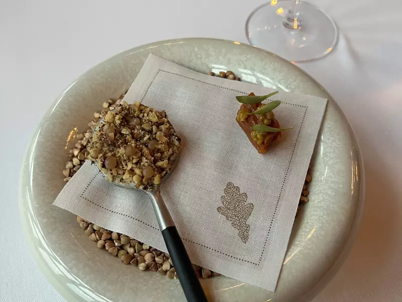 A round dish of grain with a spoon resting on a napkin.