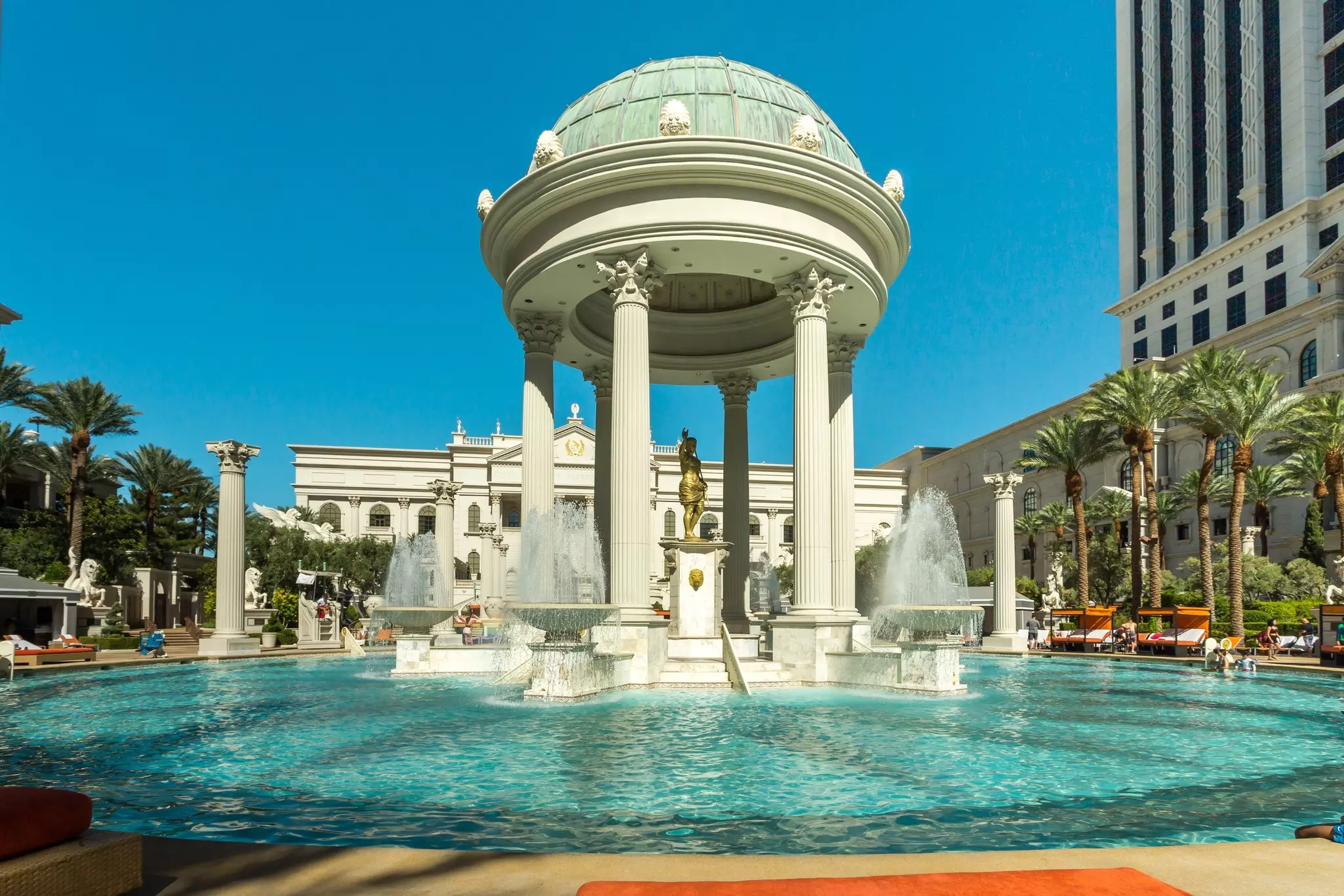 A cupola structure supported by columns stands in the middle of an exterior swimming pool at a resort hotel.