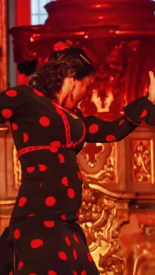 Close-up of a flamenco dancer in a red and black polka dress performing with passion