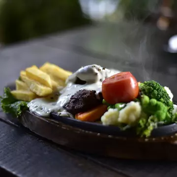 Appetizer; Backgrounds; Cheese; Close-up; Cooked; Cooking; Crockery; Cultures; Dinner; Food; Food and Drink; Freshness; Fried; Gourmet; Healthy Eating; Herb; Horizontal; Lunch; Meal; Meat; Nepal; No People; Onion; Pepper - Seasoning; Photography; Plate; Restaurant; Roast Dinner; Roasted; Savory Food; Savory Sauce; Sizzler; Spice; Tomato; Vegetable; Vegetarian Food; Wood - Material;
A hot plate BBQ steak sizzler with pepper cheese sauce, tomato, broccoli, and french fries, served in Pokhara.