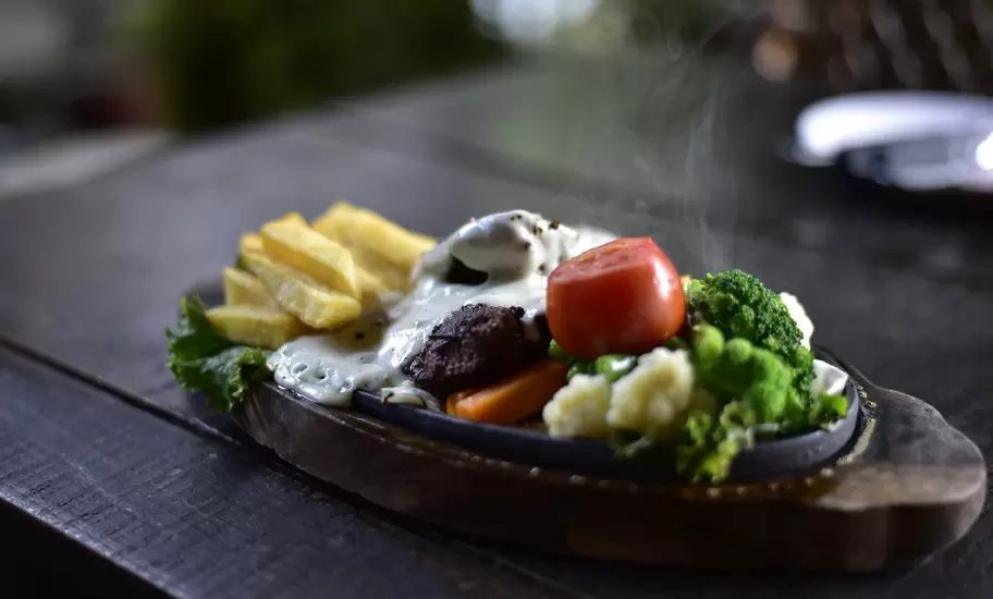 Appetizer; Backgrounds; Cheese; Close-up; Cooked; Cooking; Crockery; Cultures; Dinner; Food; Food and Drink; Freshness; Fried; Gourmet; Healthy Eating; Herb; Horizontal; Lunch; Meal; Meat; Nepal; No People; Onion; Pepper - Seasoning; Photography; Plate; Restaurant; Roast Dinner; Roasted; Savory Food; Savory Sauce; Sizzler; Spice; Tomato; Vegetable; Vegetarian Food; Wood - Material;
A hot plate BBQ steak sizzler with pepper cheese sauce, tomato, broccoli, and french fries, served in Pokhara.