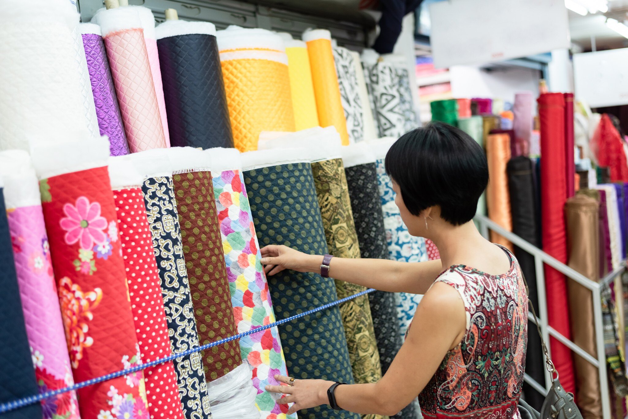 Woman picks through rolls of colorful cloth at the Yongle Market fabric mall in Taipei. 