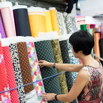 Woman picks through rolls of colorful cloth at the Yongle Market fabric mall in Taipei. 