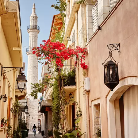 Flower strewn street , with a tall building in the distance. 