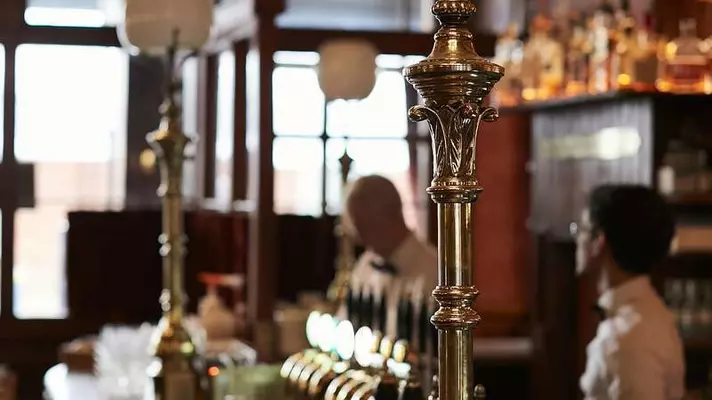 A wooden bar decorated with green tiles