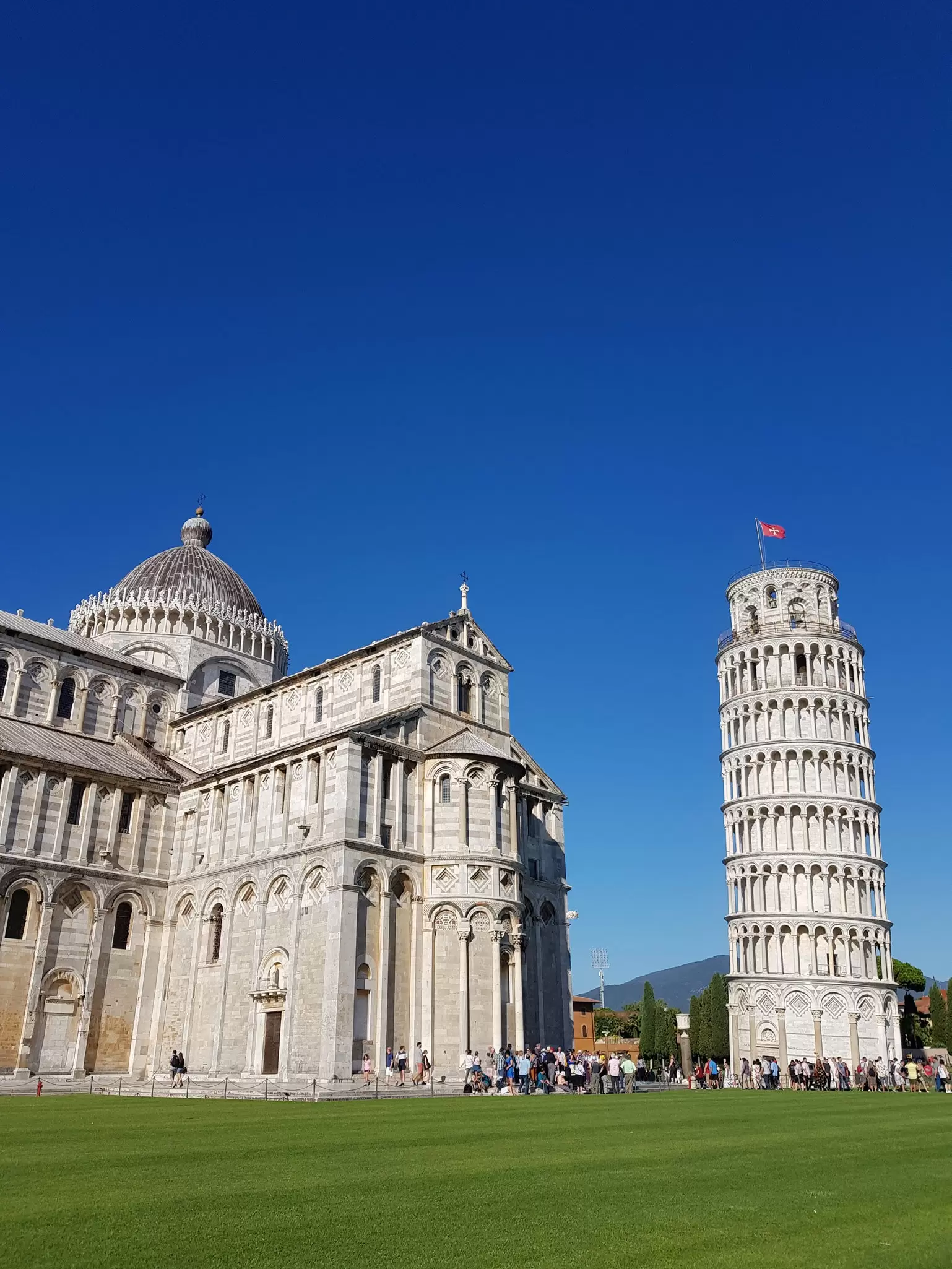 Crowds of people gathered outside the Piazza dei Miracoli and the Leaning Tower of Pisa.