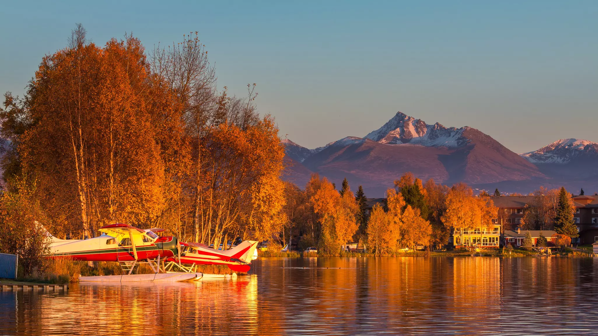 Warm colors of sunset on seaplanes at Spenard Lake in Anchorage, Alaska.