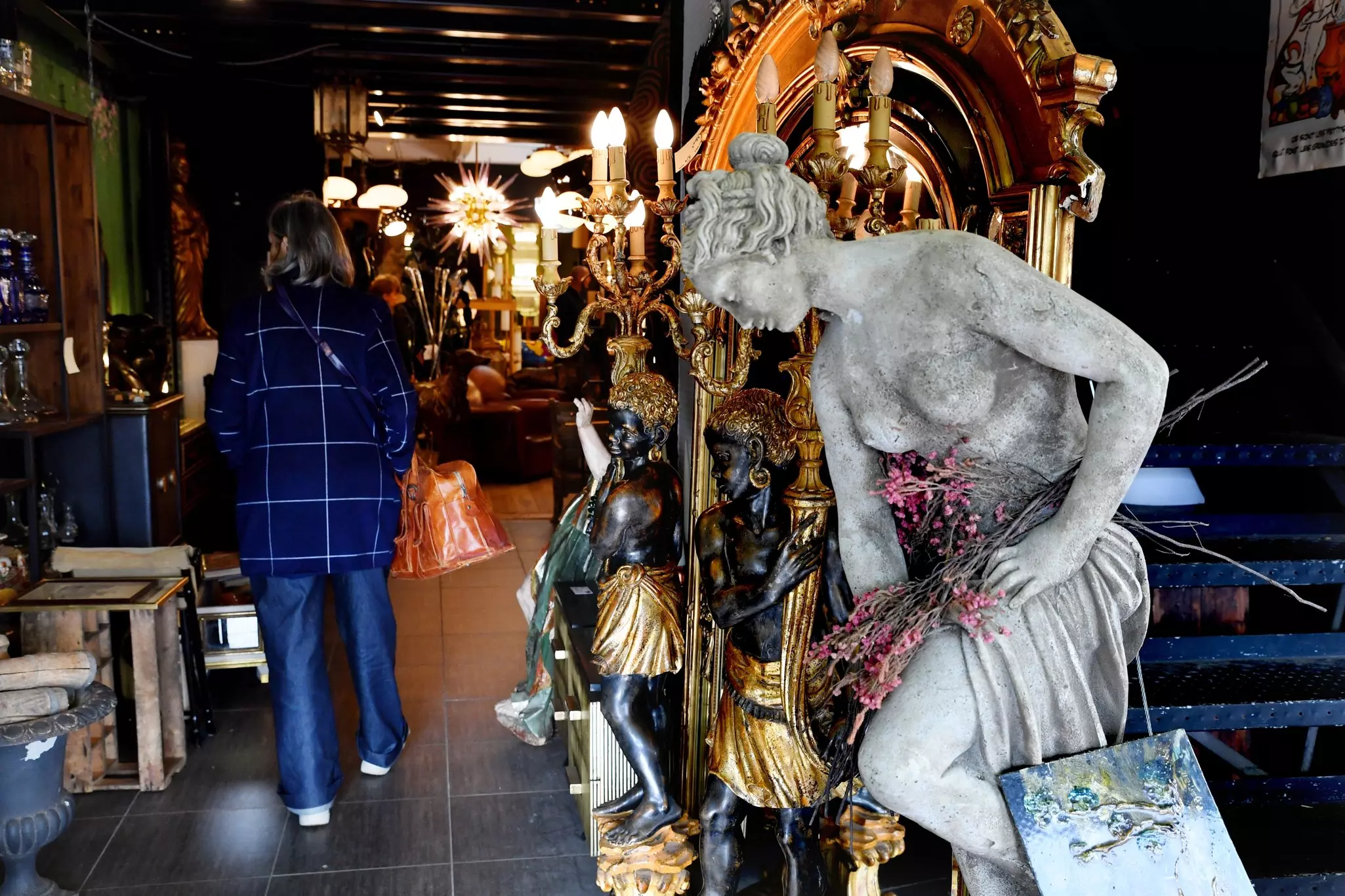 Statues, light fixtures and other antiques are for sale at a flea market.