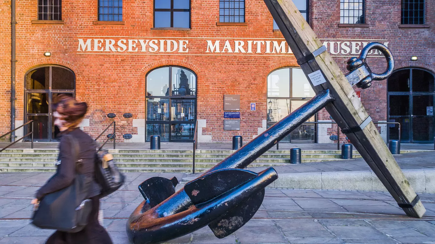 People walk past the entrance of the Merseyside Maritime Museum