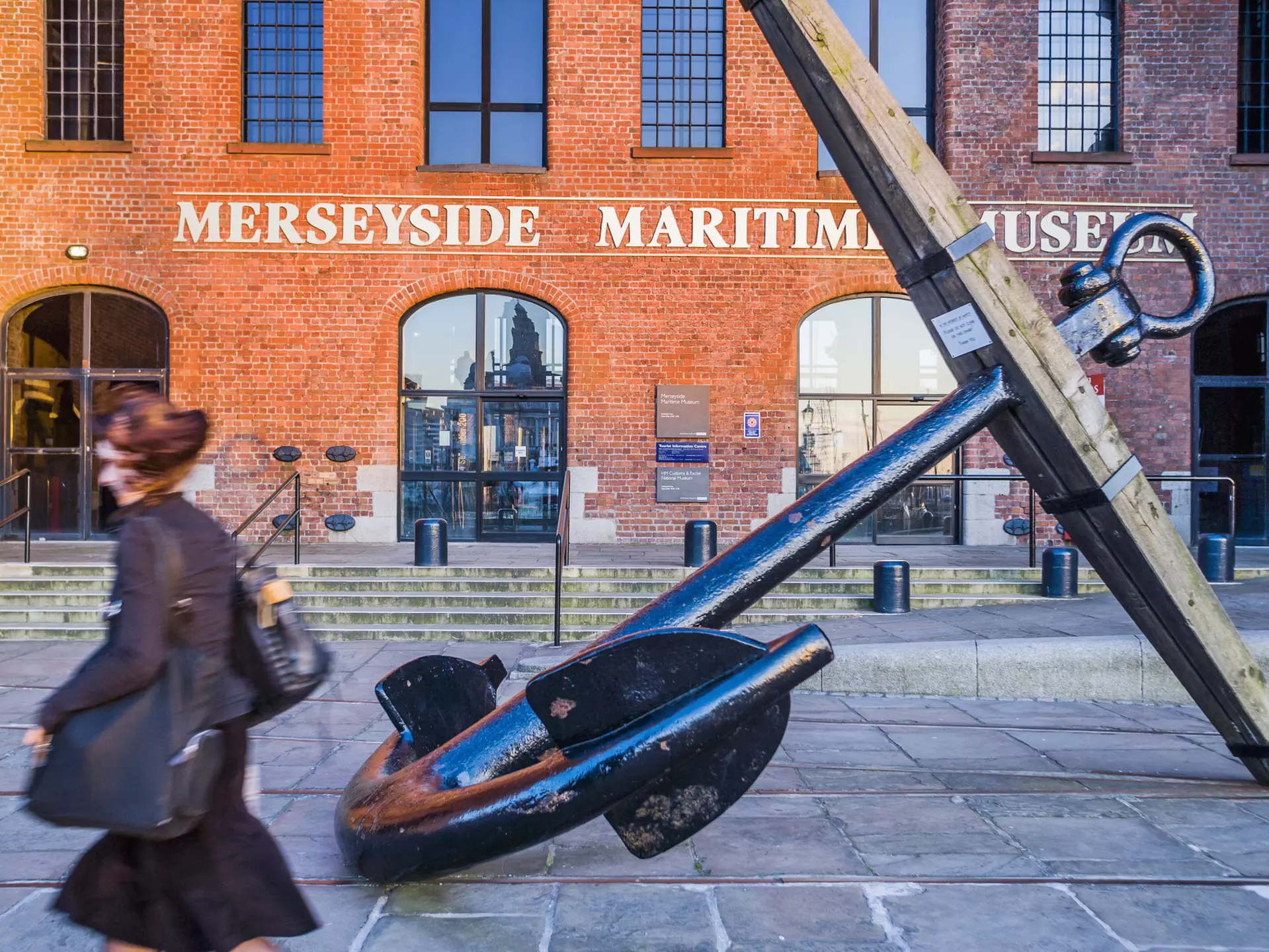 People walk past the entrance of the Merseyside Maritime Museum