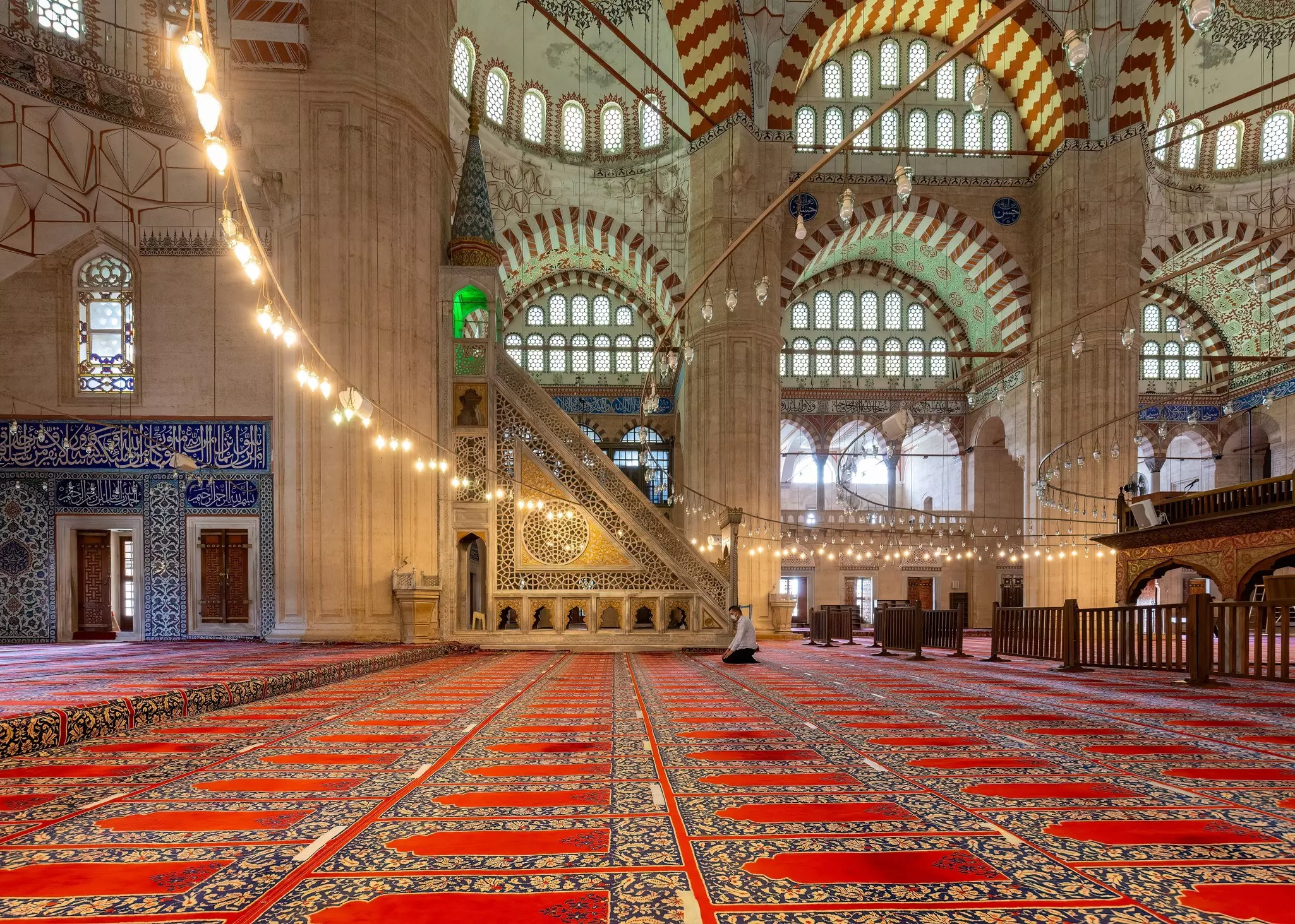 A man prays in an ornate Turkish mosque.  