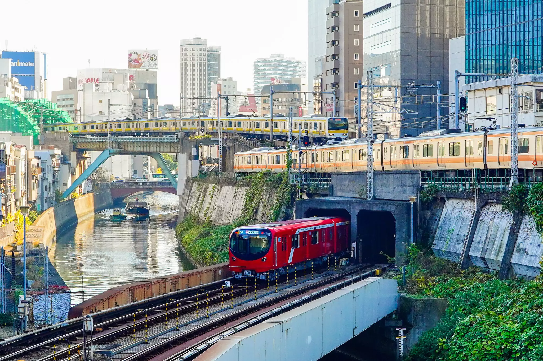 Three different trains cross bridges near each other in a city in Japan.