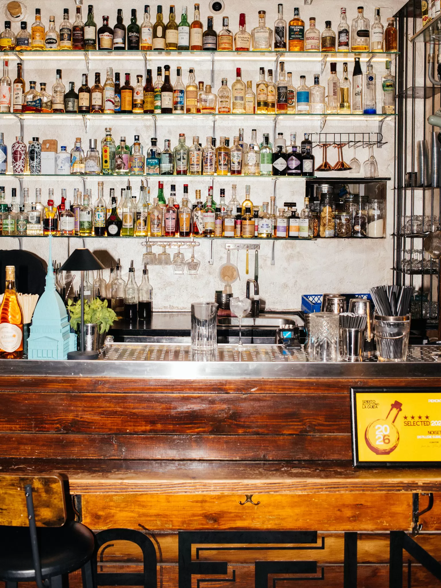 The bar inside Bar Affini in Turin, Italy. Colorful bottles line the shelves. 