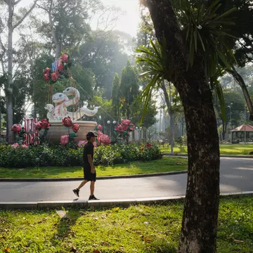 A man enjoys a peaceful walk around Tao Dan Park in Ho Chi Minh City, Vietnam.