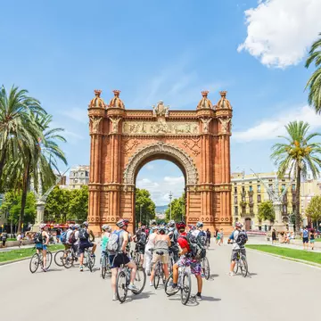 Tourists on a bicycling tour by the Arc de Triomf in Barcelona, Spain.