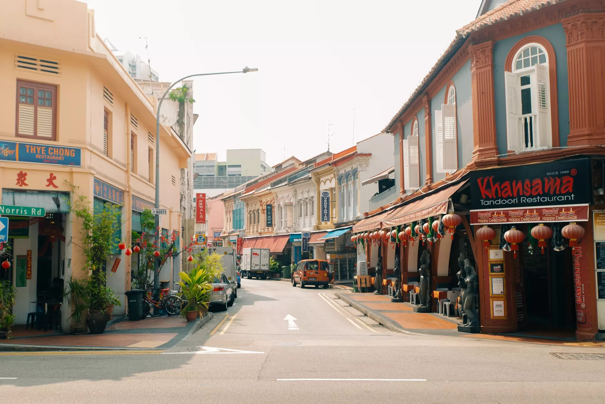 The intersection of two streets, one of which is lined with traditional two-story Chinese-style buildings.