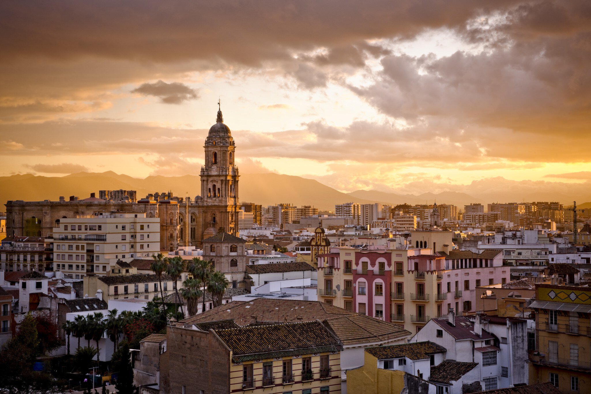 A sunset skyline view of Málaga, the capital of the Costa del Sol in Andalusia, Spain.