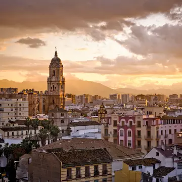 A sunset skyline view of Málaga, the capital of the Costa del Sol in Andalusia, Spain.