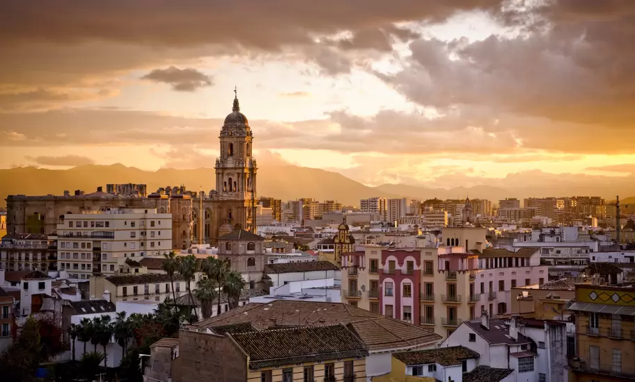 A sunset skyline view of Málaga, the capital of the Costa del Sol in Andalusia, Spain.