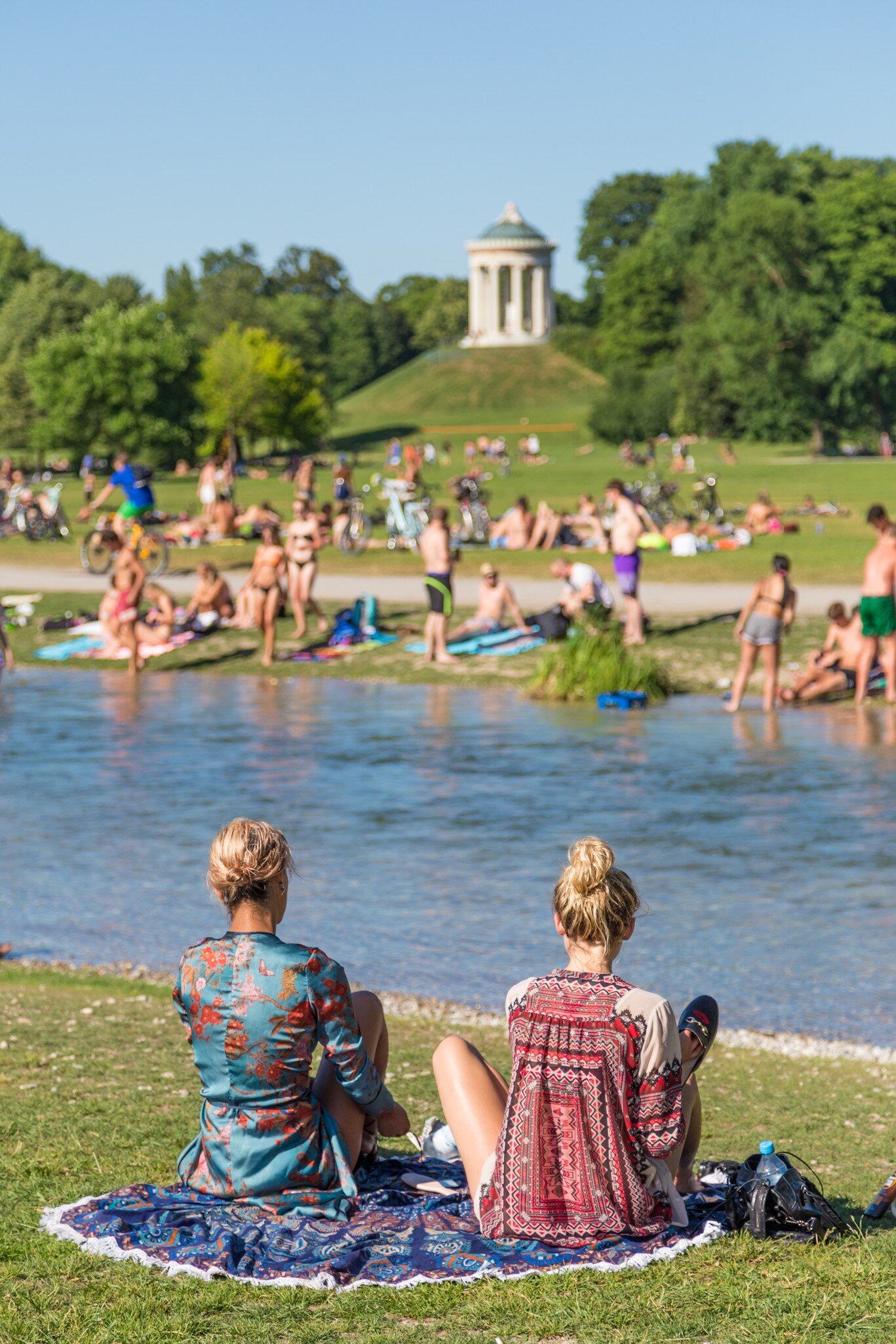 People enjoying the summer, sunbathing, swimming in Isar River in the Englischer Garten in Munich, Germany.