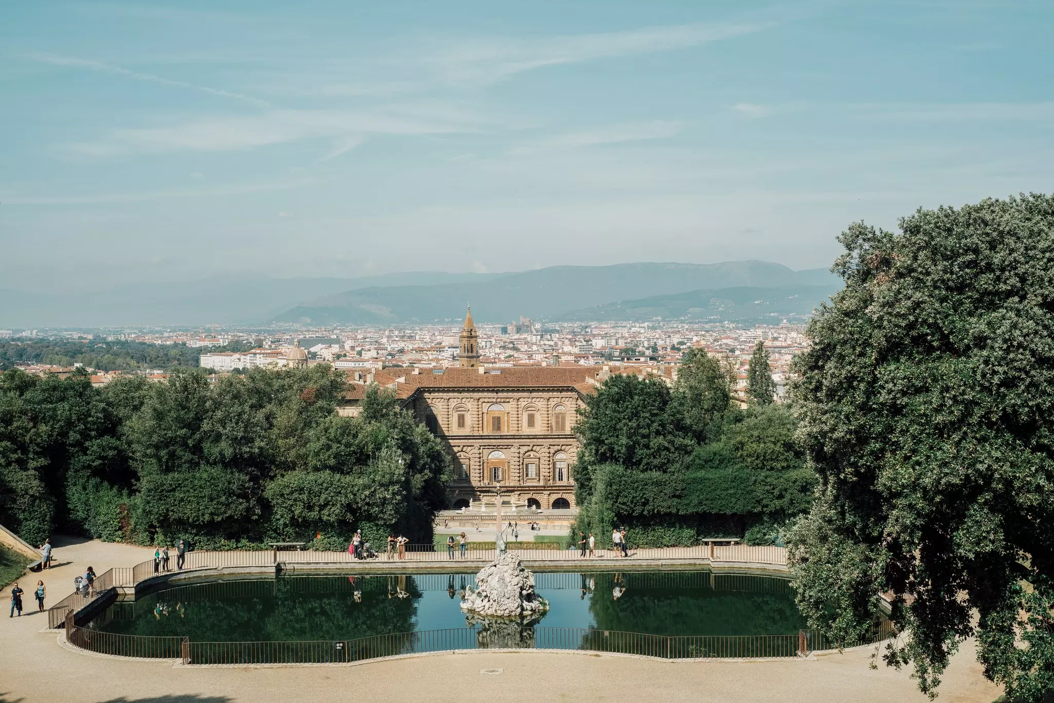 Boboli Gardens as seen from Palazzo Pitti, with pedestrians strolling on a slightly overcast day