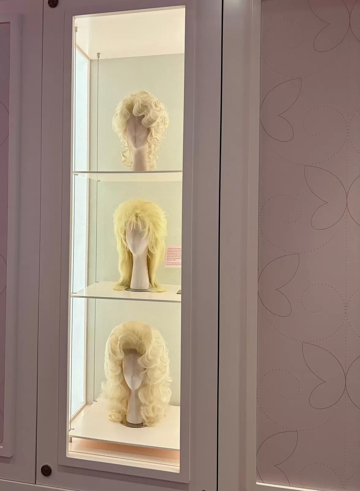 manequin heads with blond wigs on shelves 