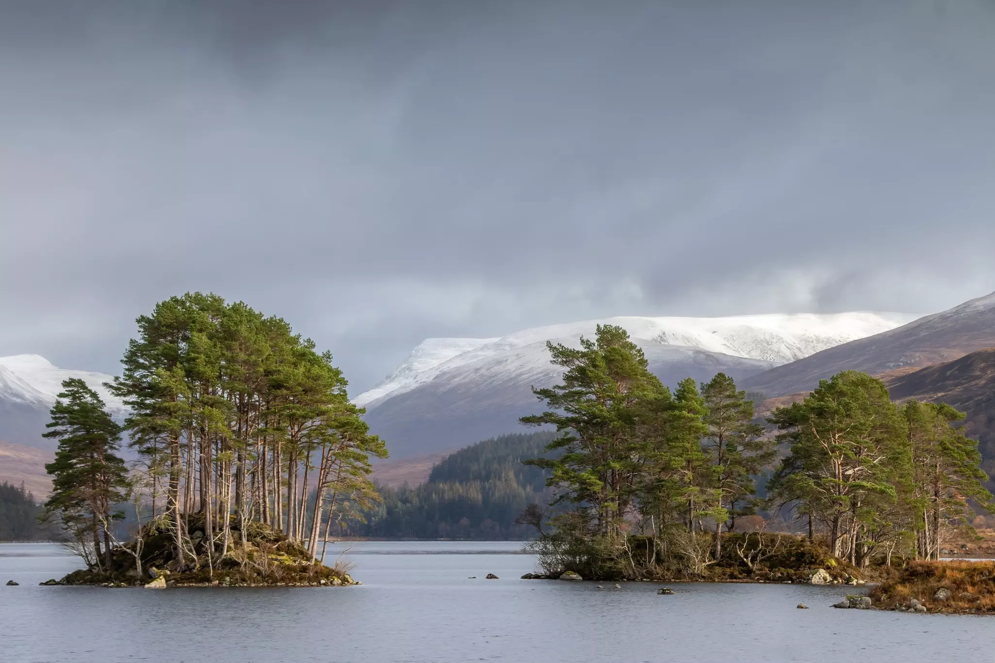 A lake surrounded by snow-topped hills near Corrour in Scotland.
