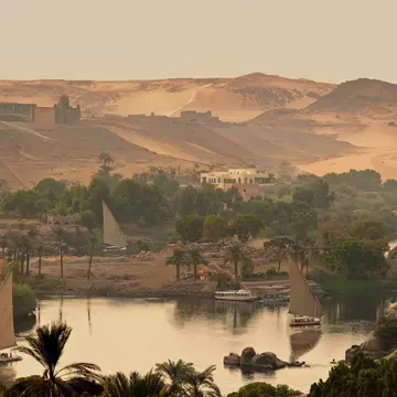 Felucca boats sailing on the Nile River. The Aga Khan’s domed mausoleum sits on the hill in the background. ©Peter Seaward/Lonely Planet