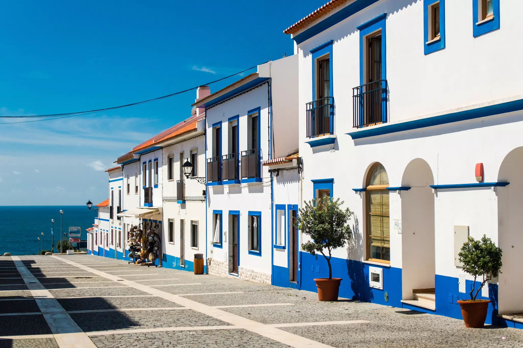 Traditional blue-and-white Alentejo Portuguese buildings line Porto Covo’s streets © Andrii Lutsyk / Shutterstock