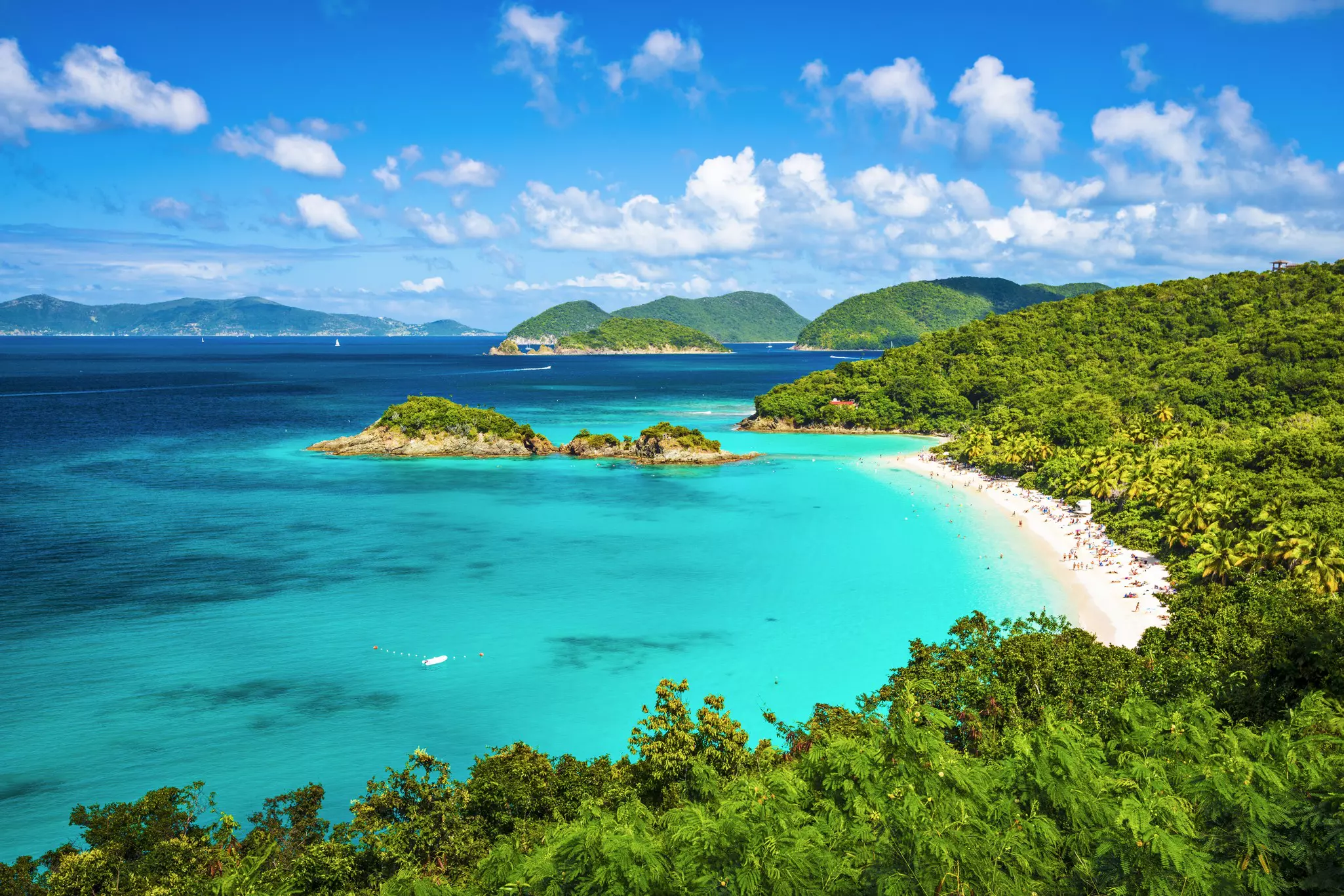 Turquoise and darker blue water surrounded by beach and plant life at Trunk Bay, St John, United States Virgin Islands