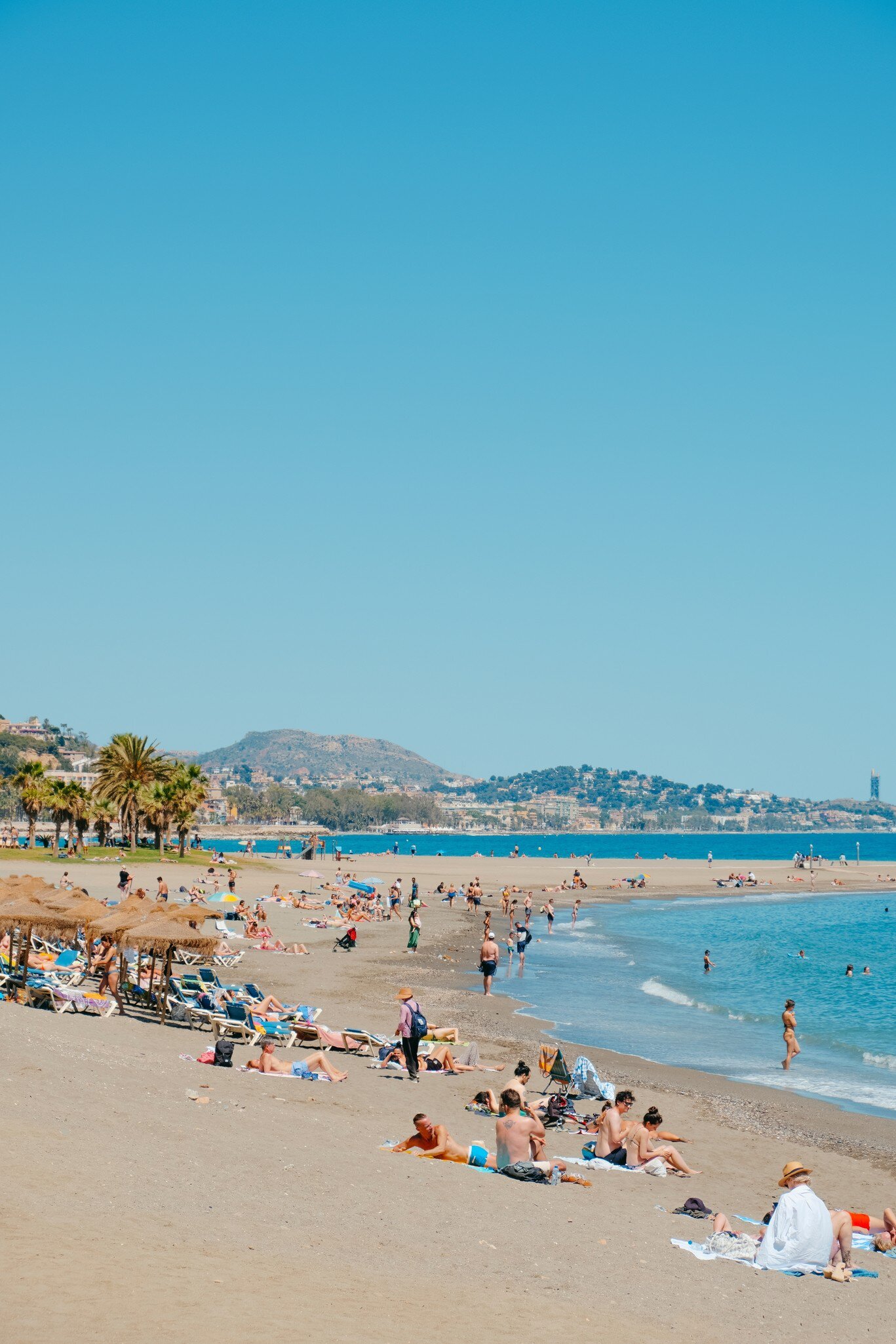People swimming at Malagueta beach in Málaga, Spain.