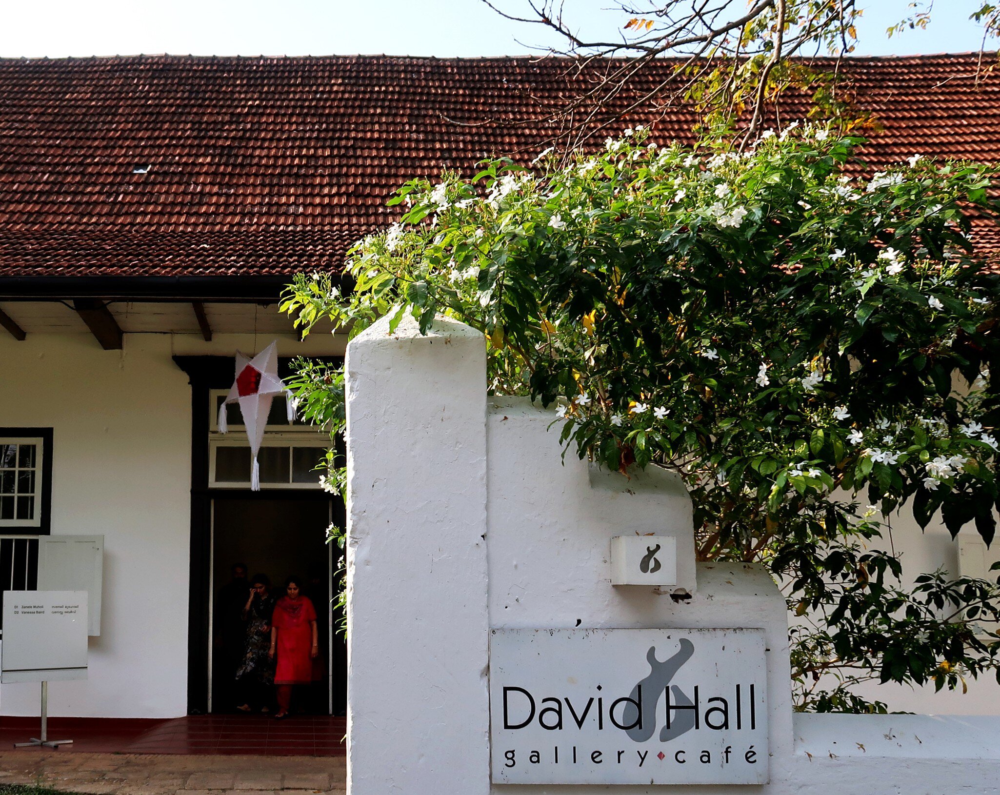A group of tourists exiting David Hall art gallery in Fort Kochi, Kerala. India.