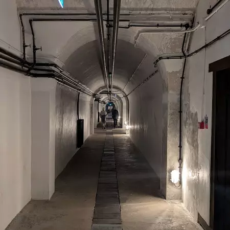 Inside view of long stone tunnel with curved archway and roof above.