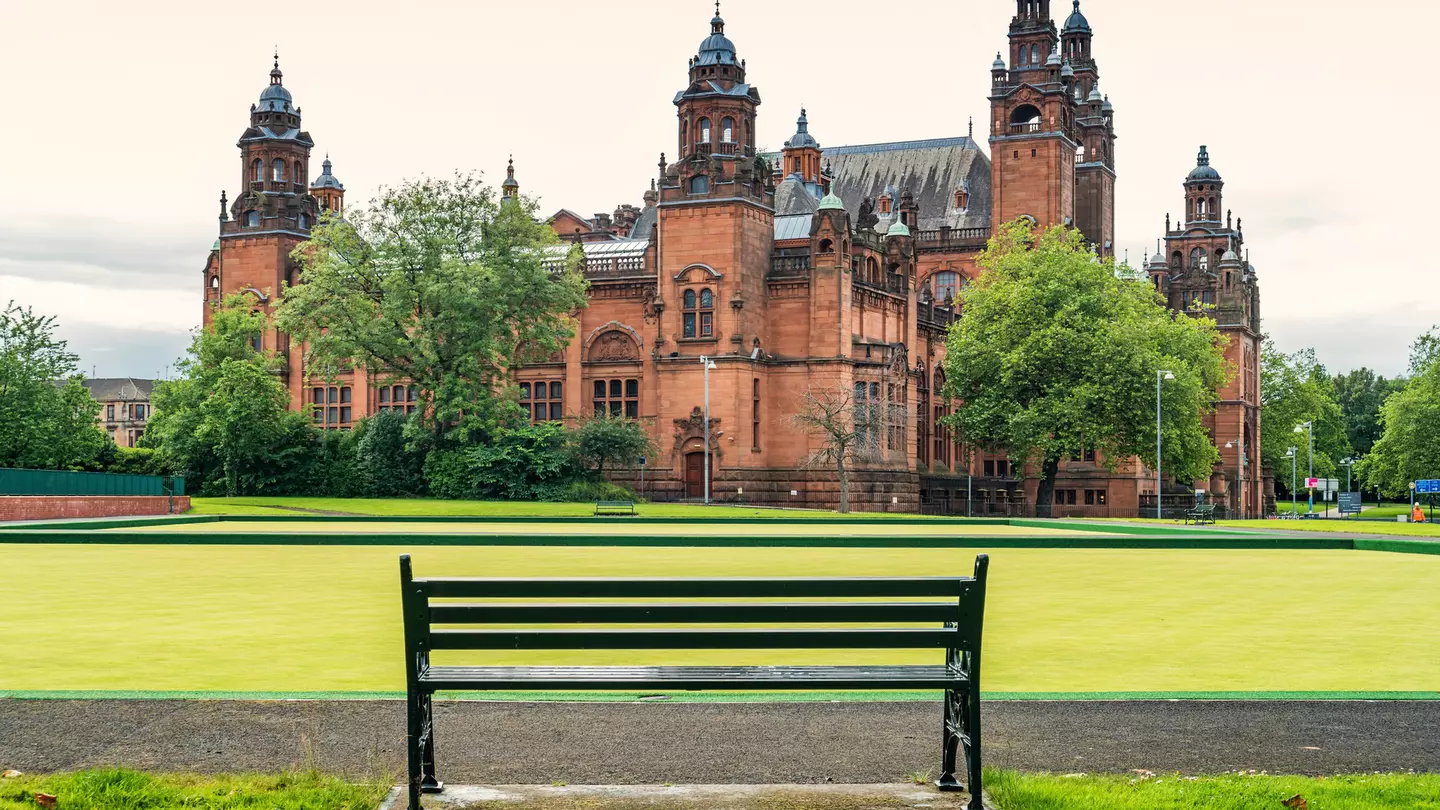 Empty bench with the Kelvingrove Art Gallery & Museum in the background, Glasgow, Scotland.