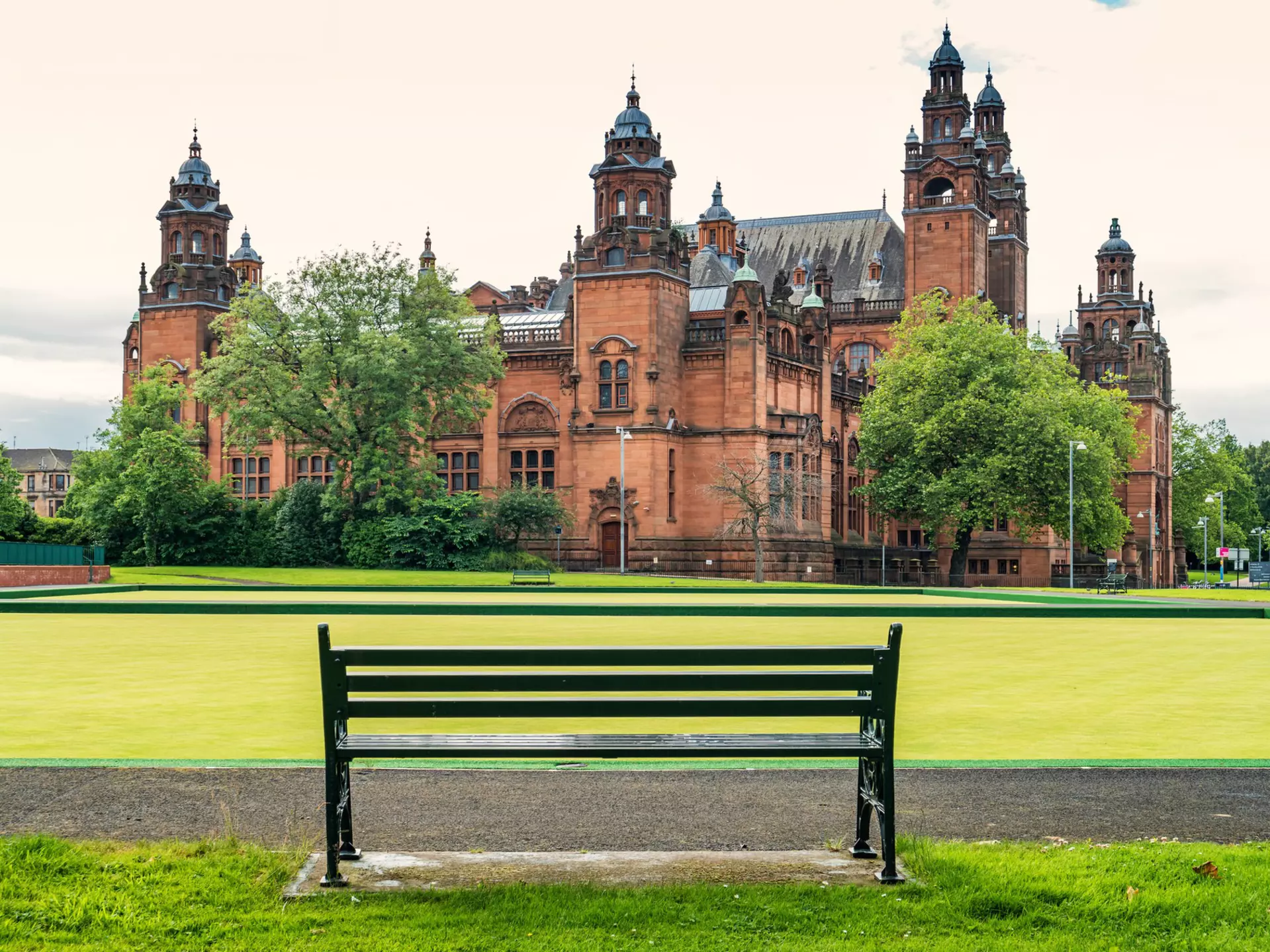 Empty bench with the Kelvingrove Art Gallery & Museum in the background, Glasgow, Scotland.