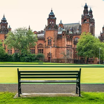 Empty bench with the Kelvingrove Art Gallery & Museum in the background, Glasgow, Scotland.