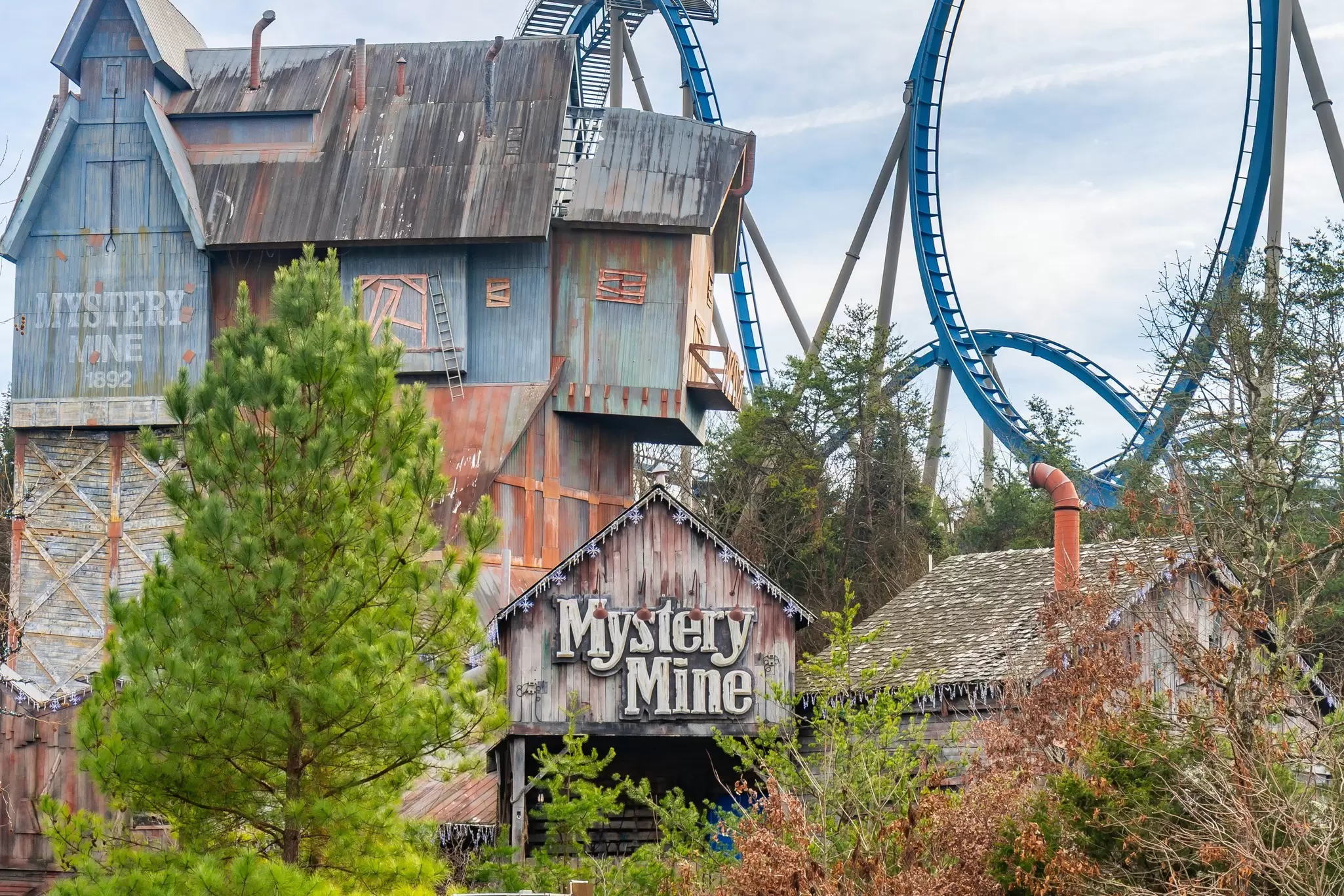 The entrance to a roller coaster with a seemingly dilapidated frontage and a sign saying "Mystery Mine" at Dollywood.
