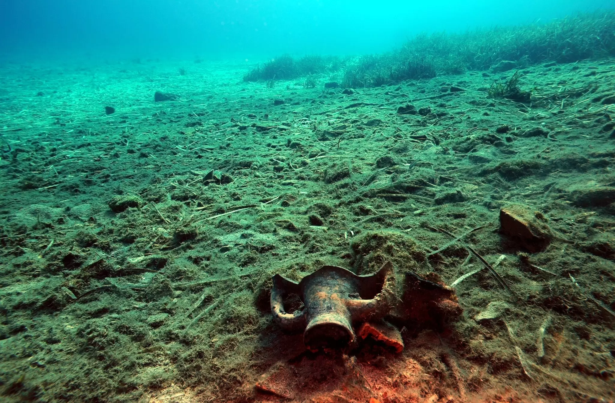 Cracked pots and pieces of pottery scattered over the seabed at a dive site in Greece.