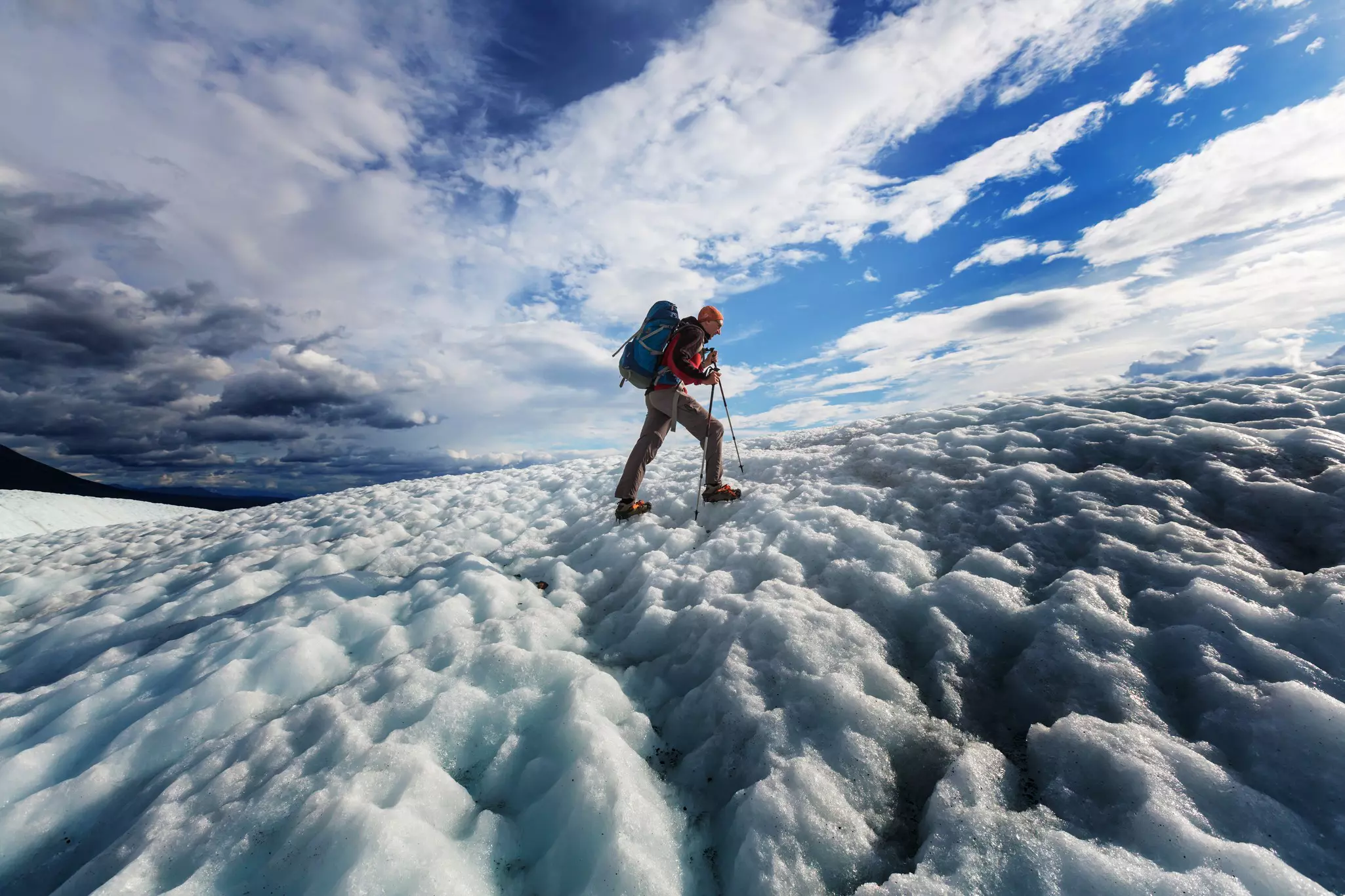 A hiker with a backpack on a snow-covered incline.