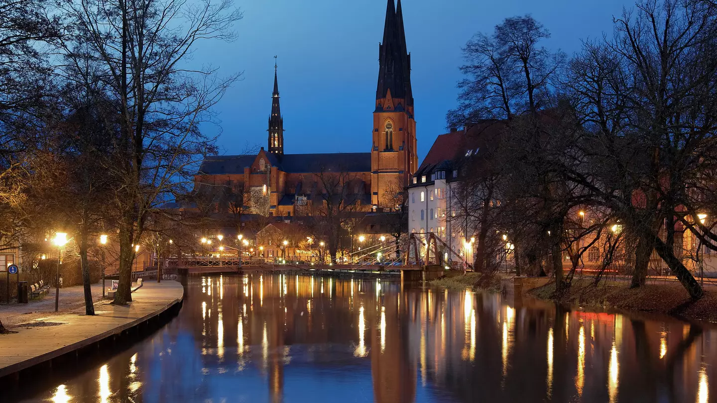 The river Fyris and the cathedral are illuminated in the evening, Uppsala, Sweden