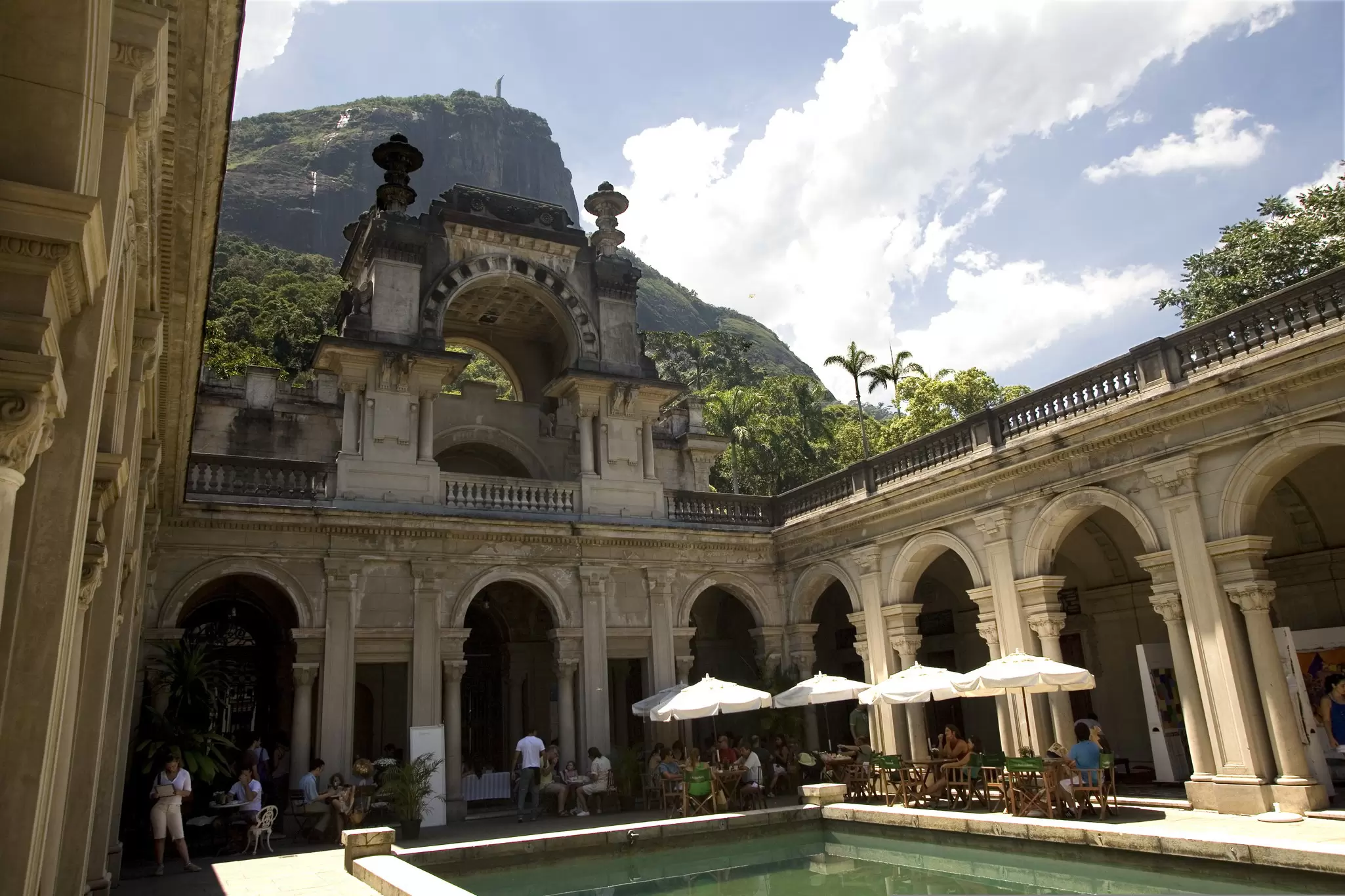 Visitors sit by the pool at the palace in Parque Lage in Rio de Janeiro, Brazil.
