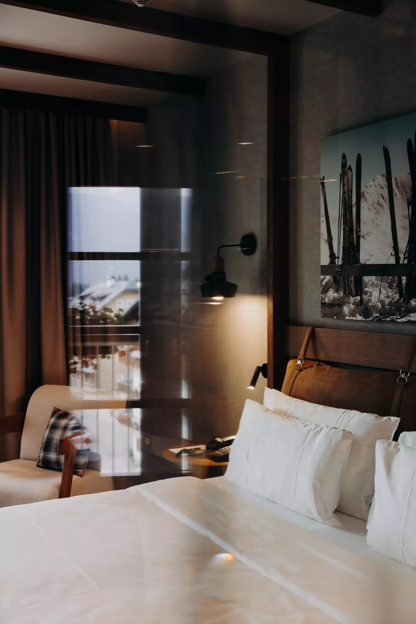 Cortina d'Ampezzo, Italy. June 2025. ..Radisson Grand Hotel Savoia - View of the room, the landscape reflects on the glass wall dividing the bed and the bathroom area...Photo by Camilla Ferrari for Lonely Planet