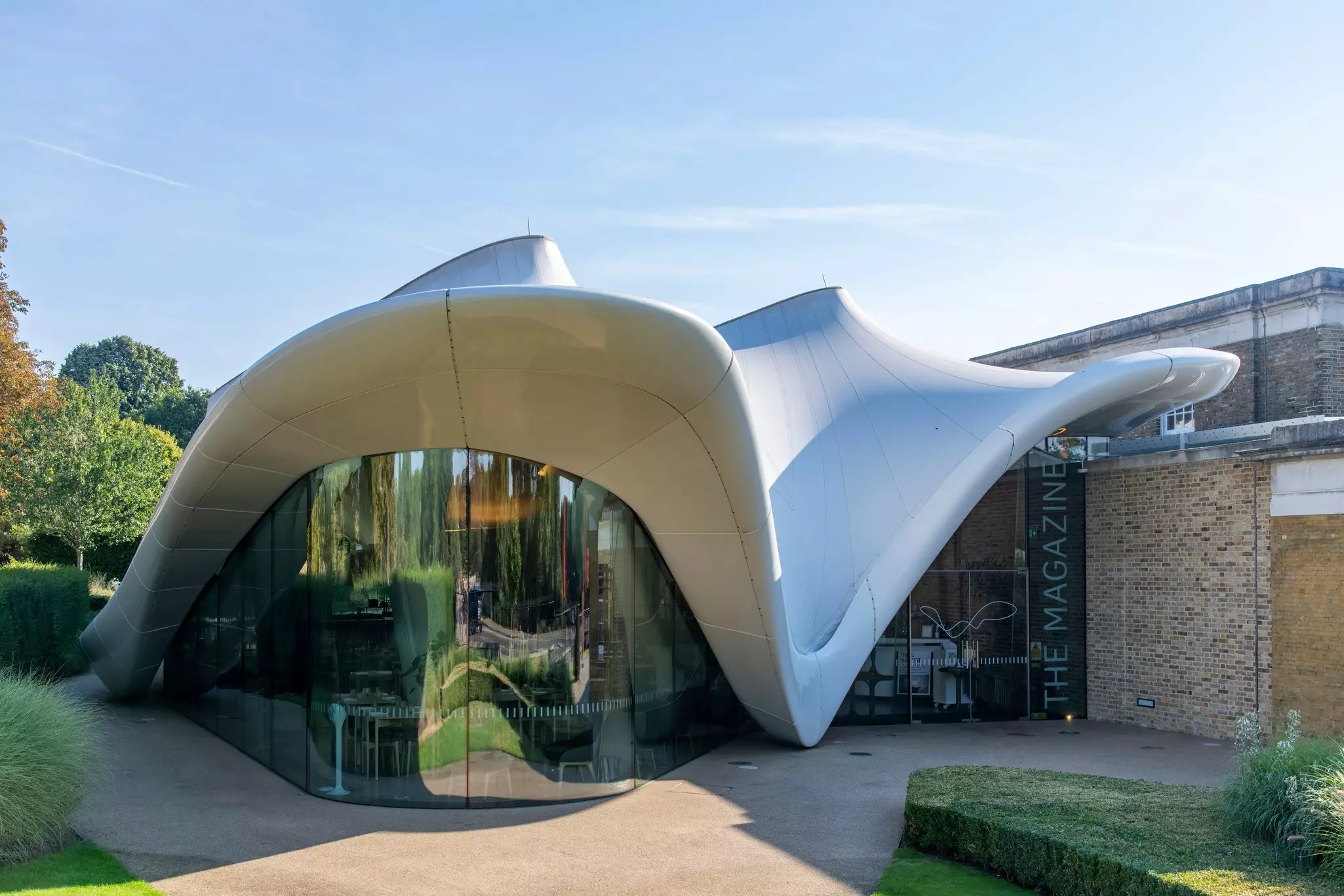 Glass on the facade of the Serpentine North Gallery, with its swooping roof, reflects the surroundings.