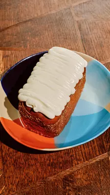 A coconut turnover on a colorful dessert plate on a wooden table. 