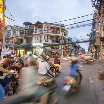 A busy street in HCMC with a crowd of scooters passing by in a blur